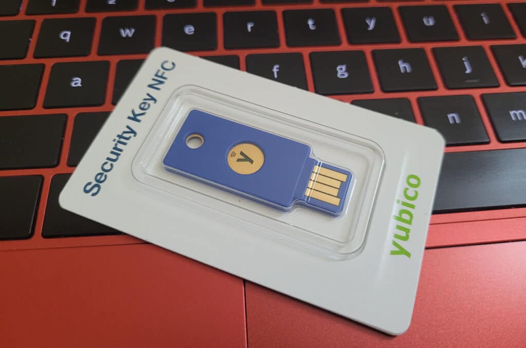 A blue Yubico Security Key in its packaging on a red keyboard.