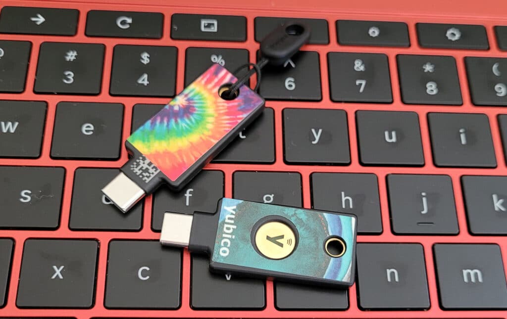 Two YubiKeys lay on top of a keyboard