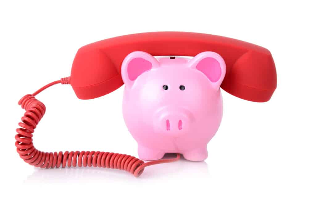 call the bank for support or telephone banking concept piggy bank with red phone receiver isolated on white